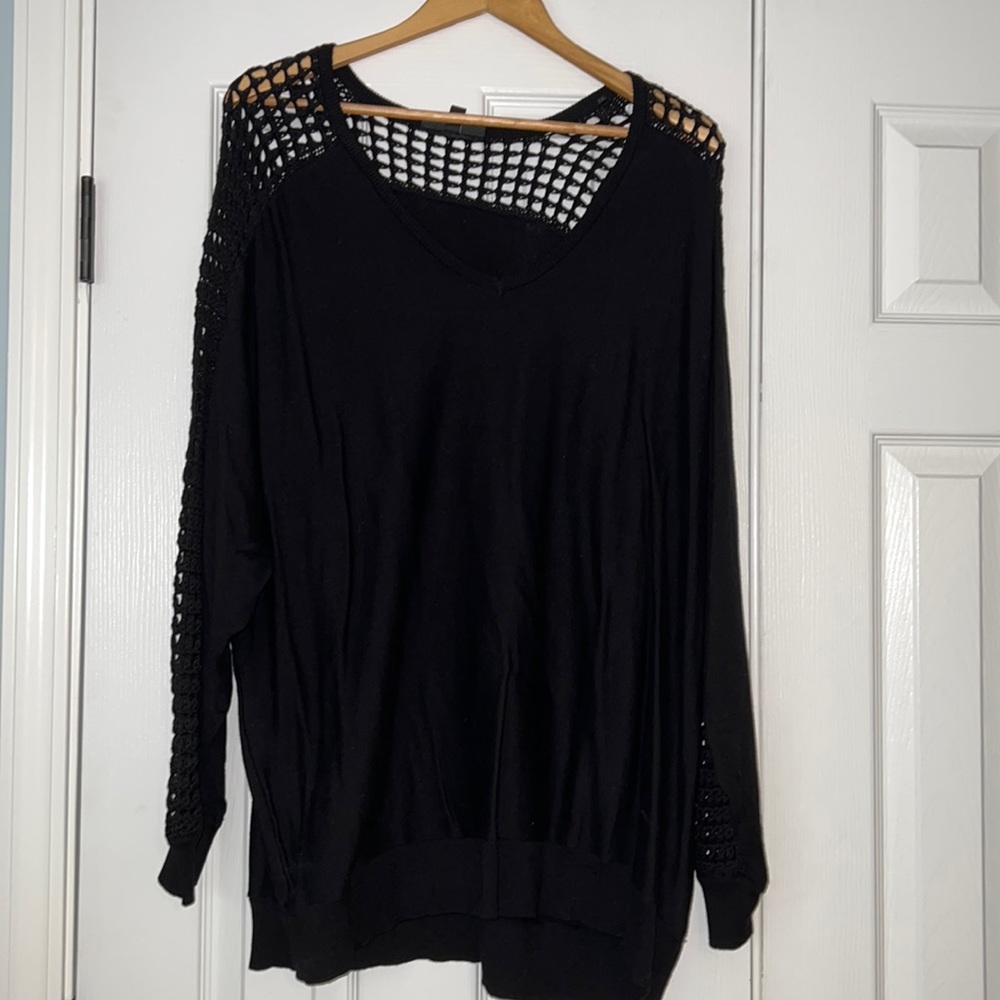 Black sweater banded hem. Open knit detail.